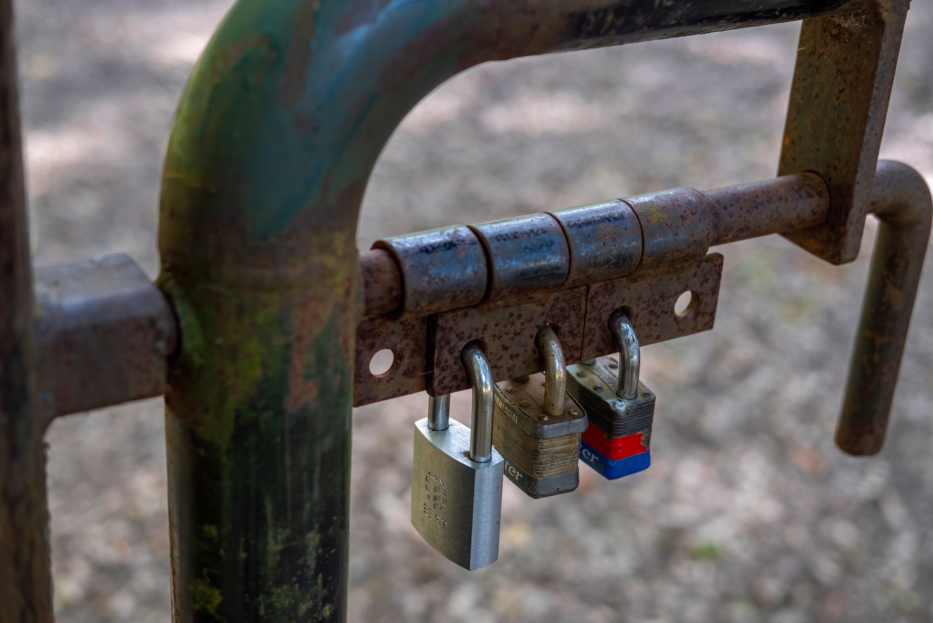 gate is locked with three padlocks